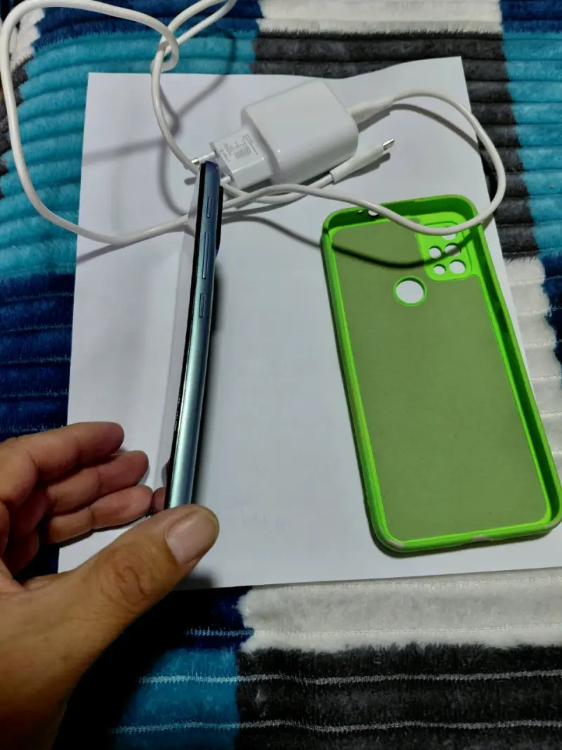 Smartphone Motorola con funda verde y cargador - 3