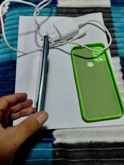 Smartphone Motorola con funda verde y cargador - miniatura 3