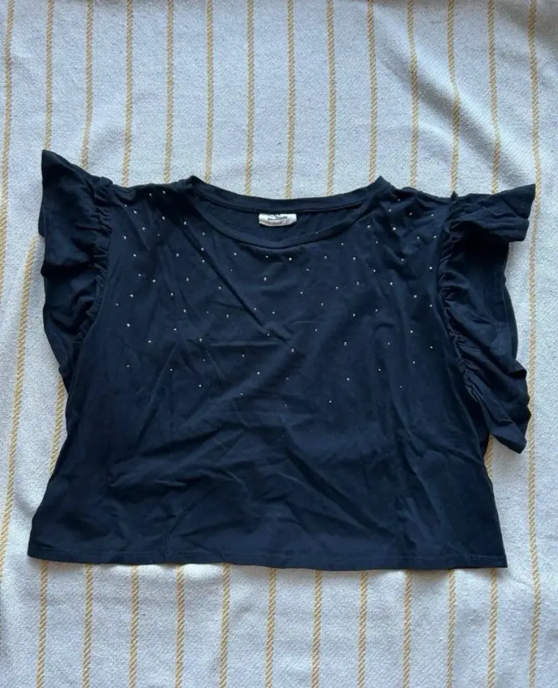 Polera negra con volantes y detalles brillantes - 1