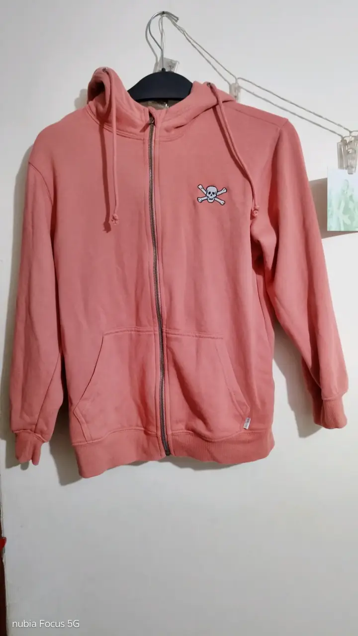 Polerón rosado con capucha y diseño de calavera