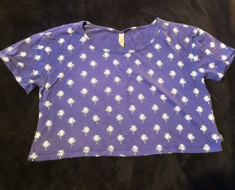 Polera azul con estampado de palmeras