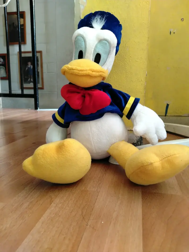 Peluche de pato con traje azul y rojo