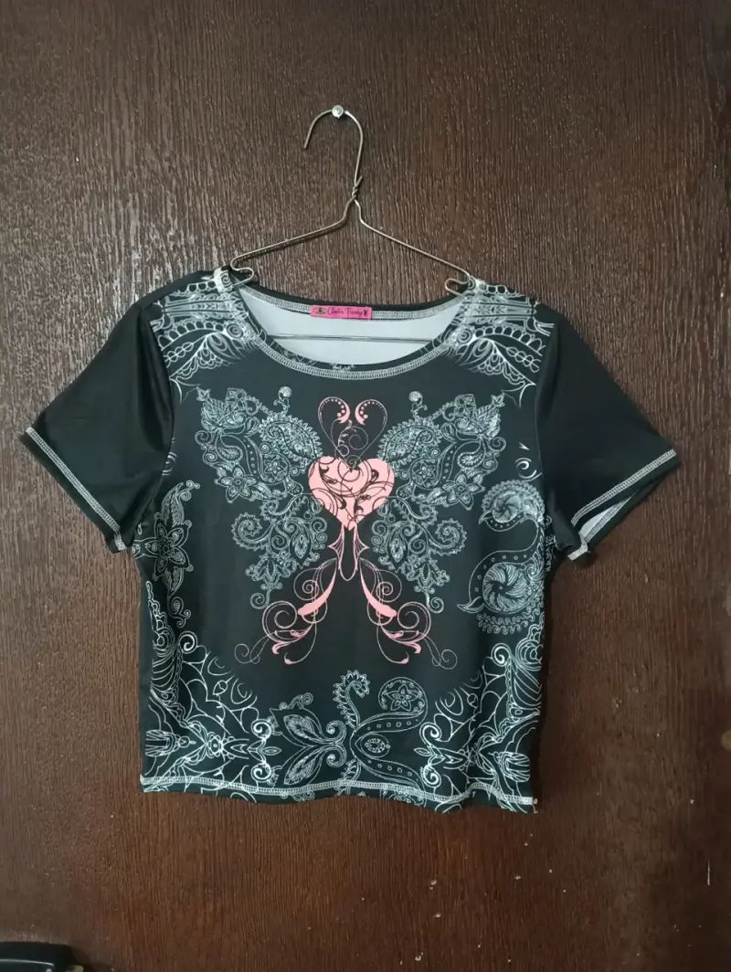 Polera negra con diseño gráfico y detalles rosados - 1
