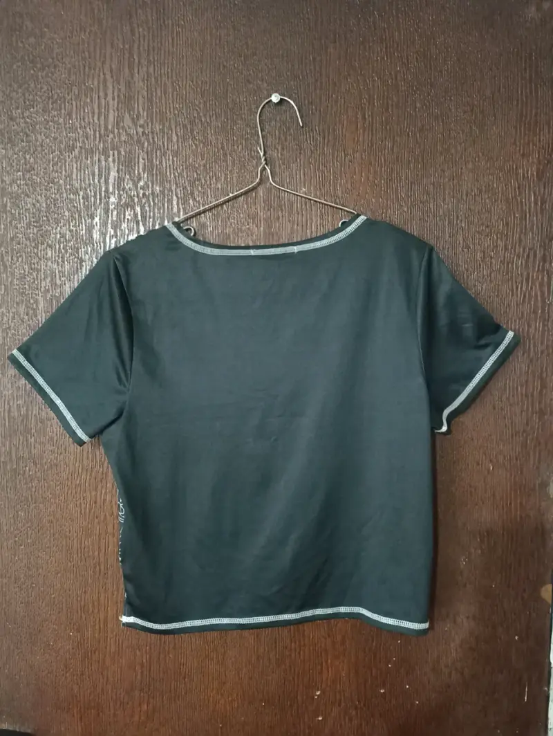 Polera negra con diseño gráfico y detalles rosados - 2