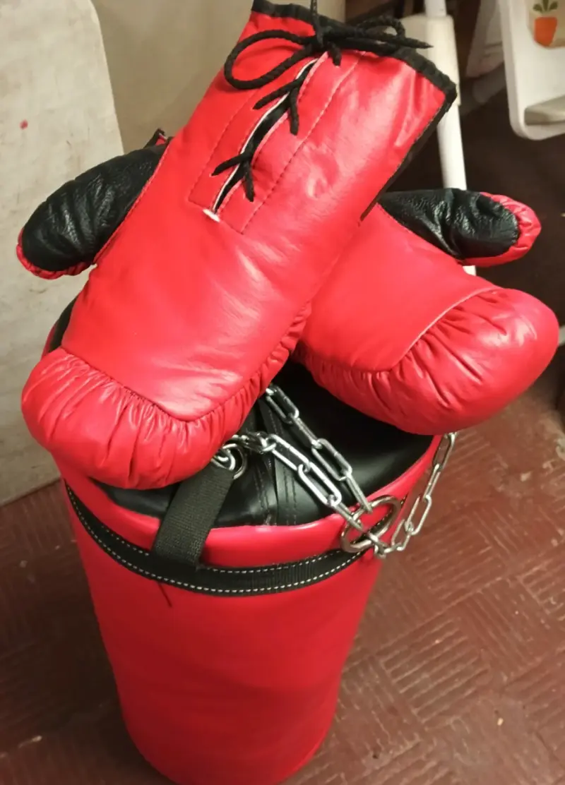 Saco de boxeo con guantes rojos, sin detalles. - 3