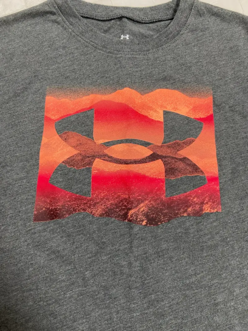 Polera Under Armour gris con logo naranja - 1