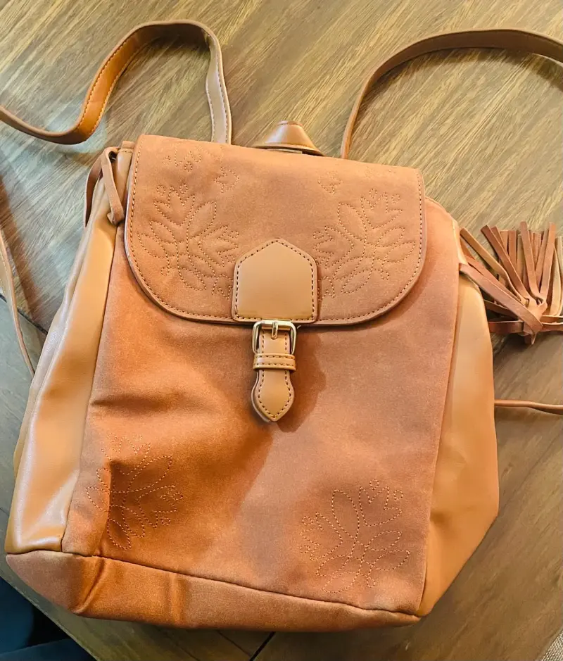 Mochila de cuero marrón con diseño floral