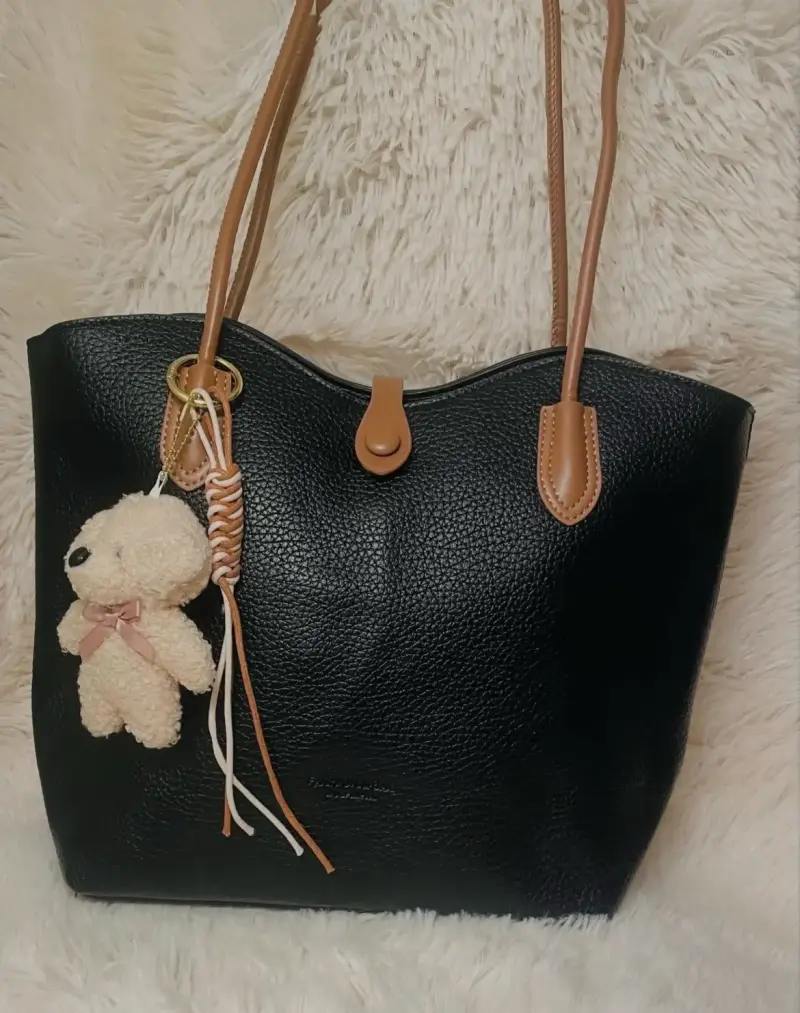 Bolso negro de cuero con colgante de oso