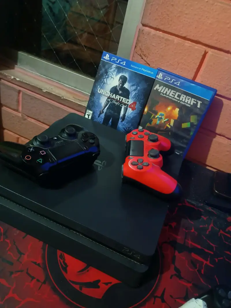 Consola PS4 con juegos y controles - 1