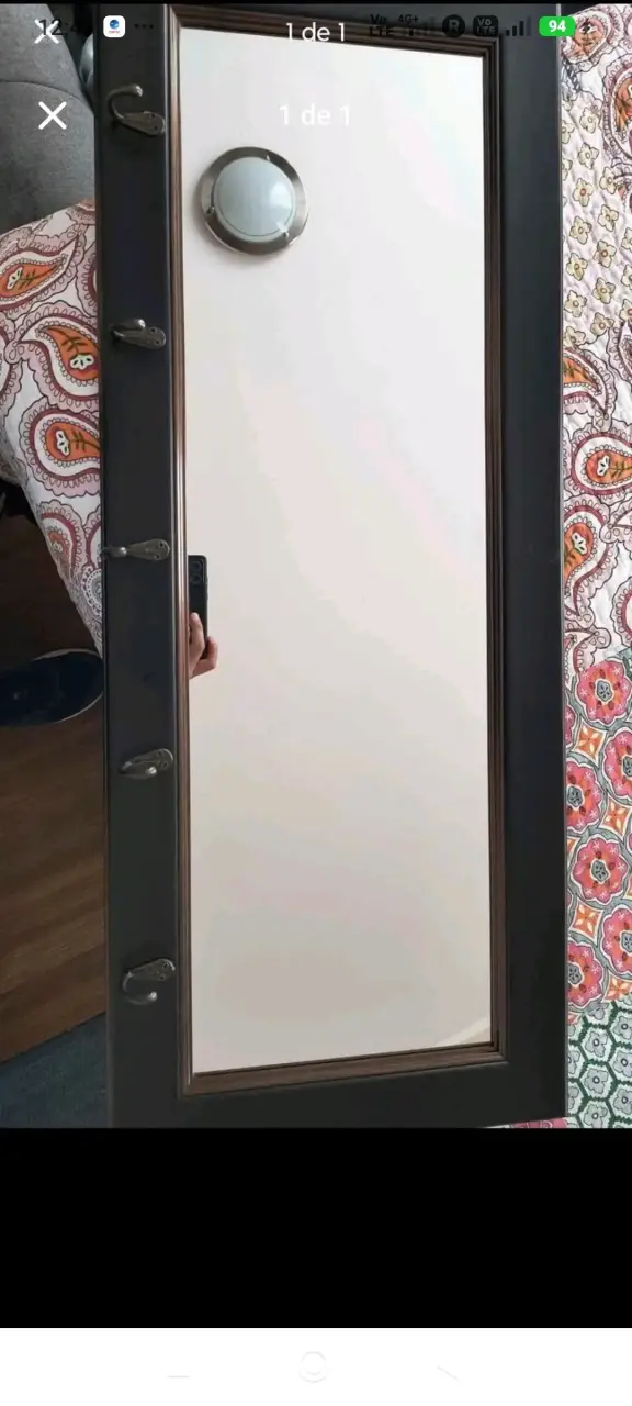 Espejo de pared con marco oscuro y ganchos