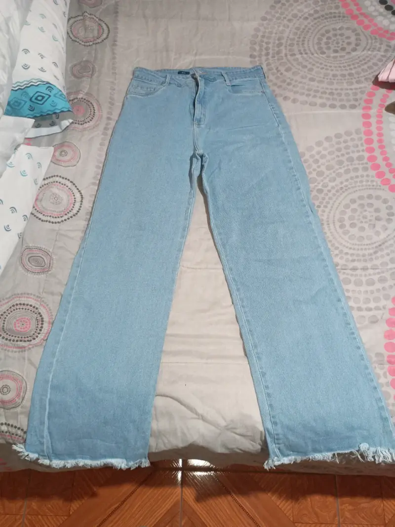Jeans celestes de mezclilla con ruedo deshilachado