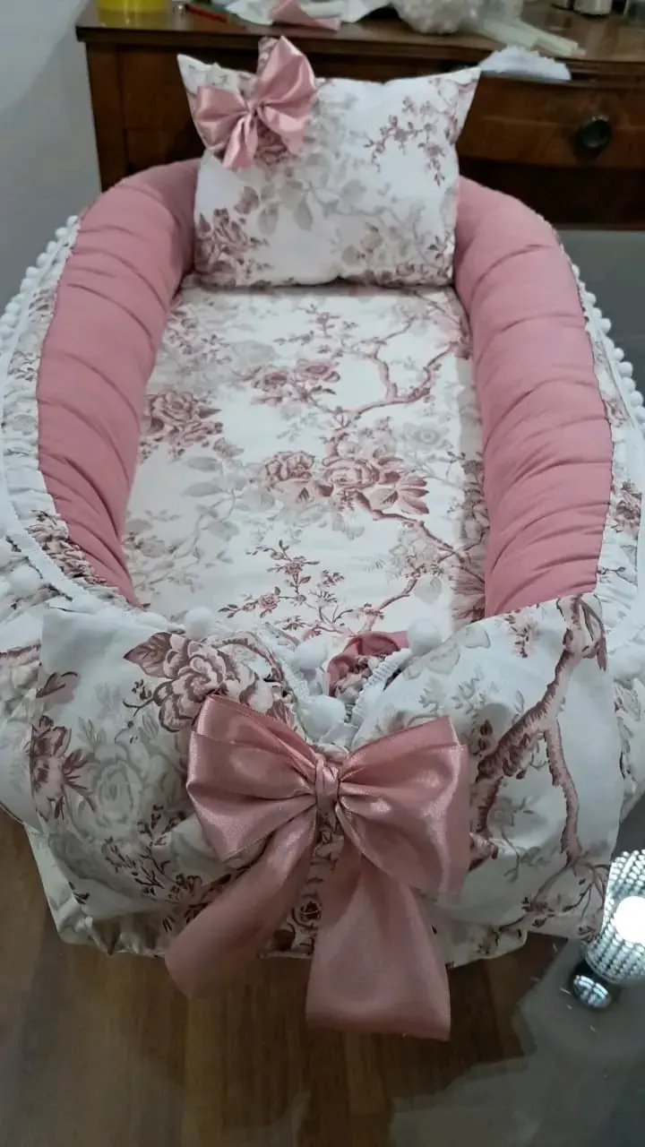 Nido para bebé con diseño floral y lazo