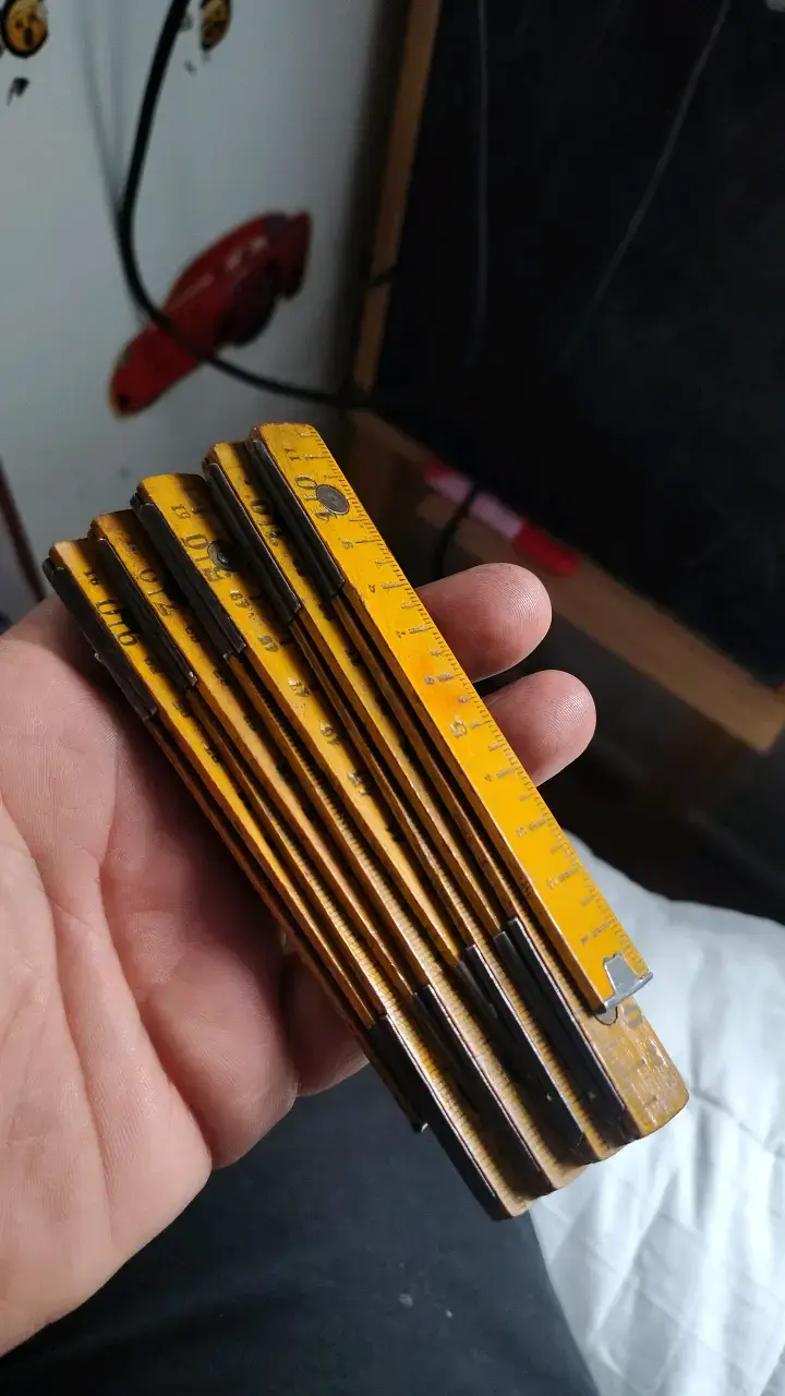 Metro plegable de madera amarillo