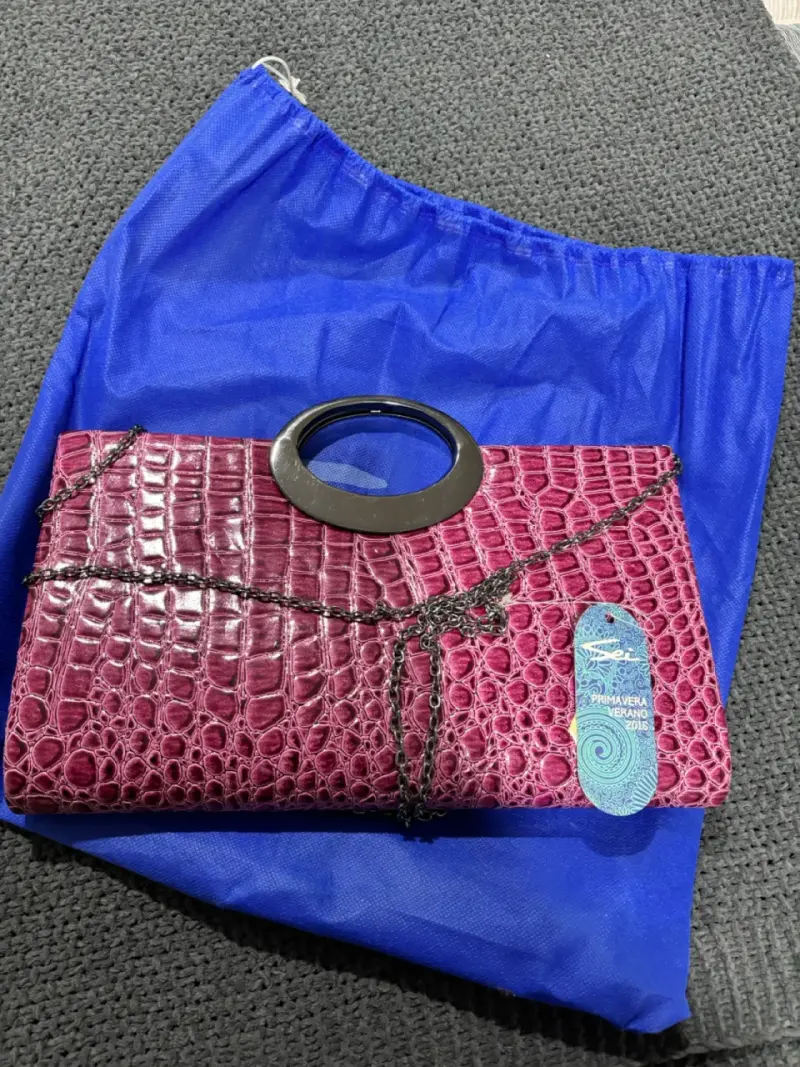 Cartera fucsia con diseño de cocodrilo