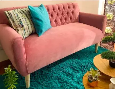 Sofá rosado de terciopelo con cojines - miniatura 1