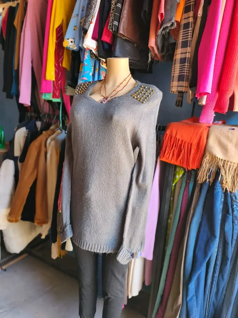 Suéter gris con tachuelas en hombros