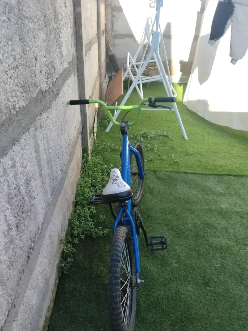 Bicicleta BMX azul con manubrio verde - 1