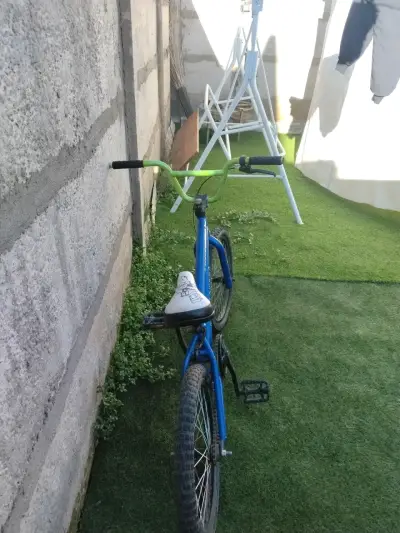 Bicicleta BMX azul con manubrio verde - miniatura 1