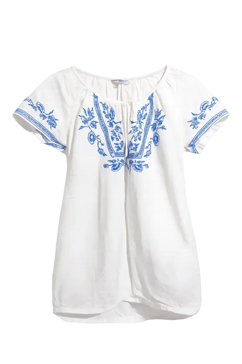 Blusa blanca bordada con diseño floral azul
