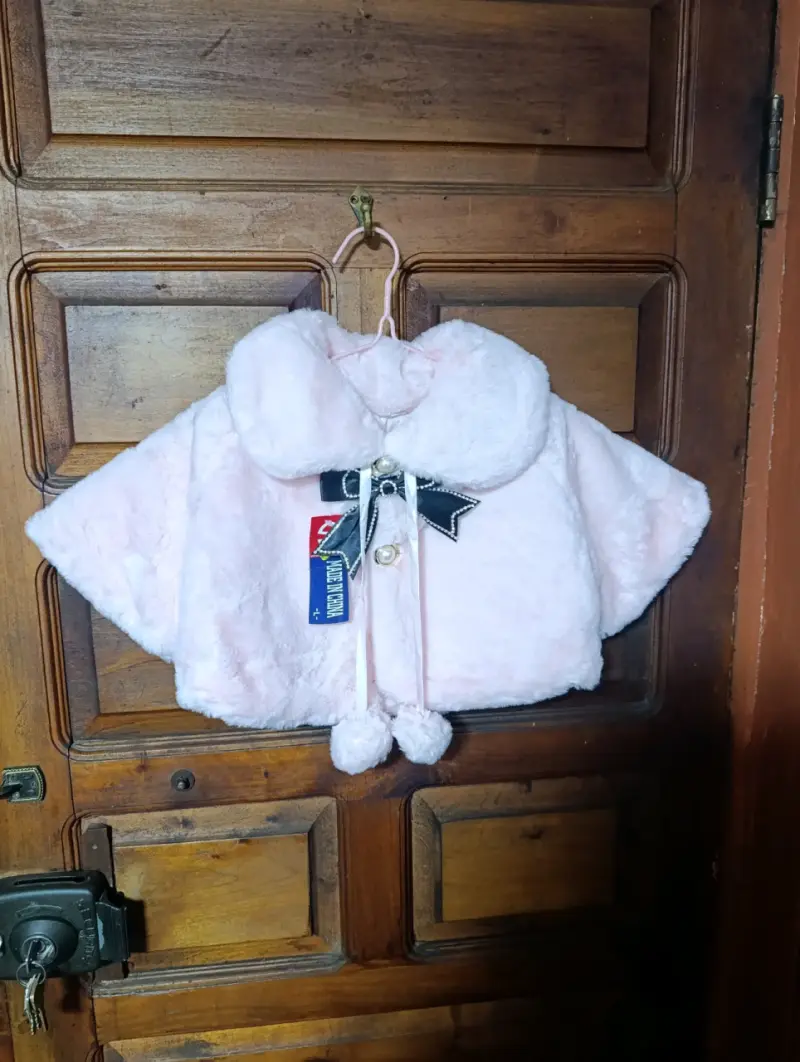 Capa de bebé rosa con lazo decorativo