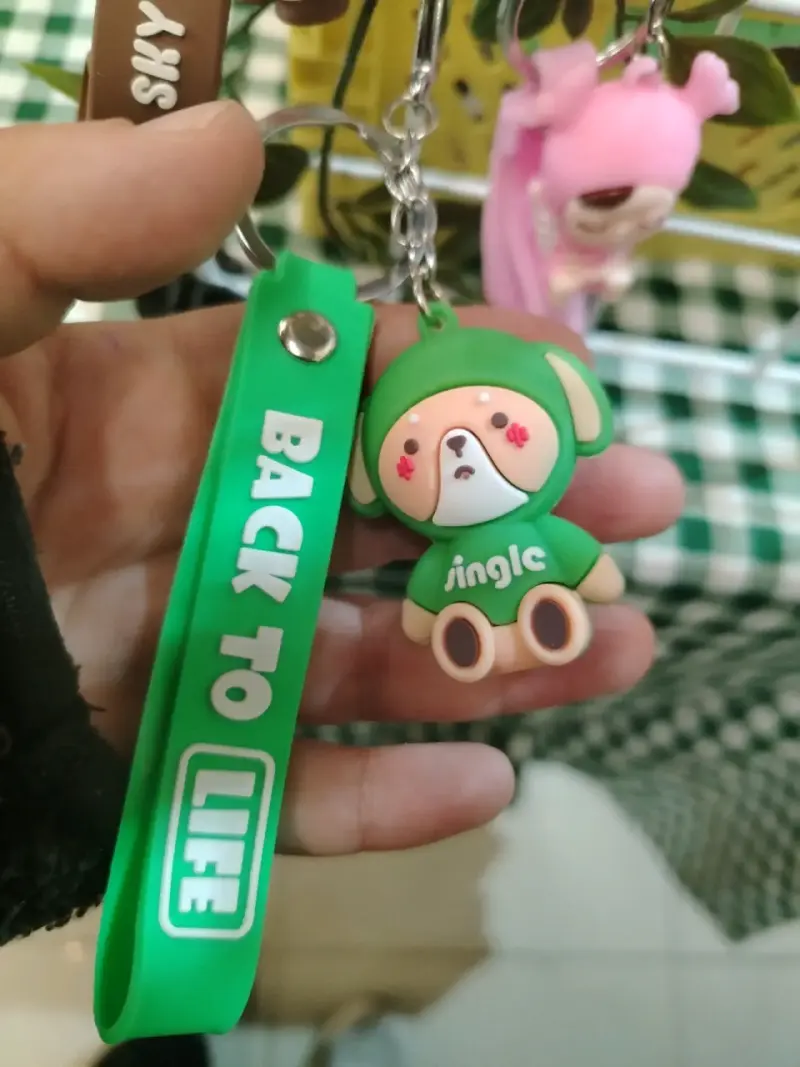 Llavero de goma verde con figura de perro