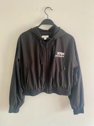 Chaqueta cortaviento negra con capucha - miniatura 1