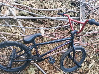 Bicicleta BMX negra con manubrio rojo - miniatura 1