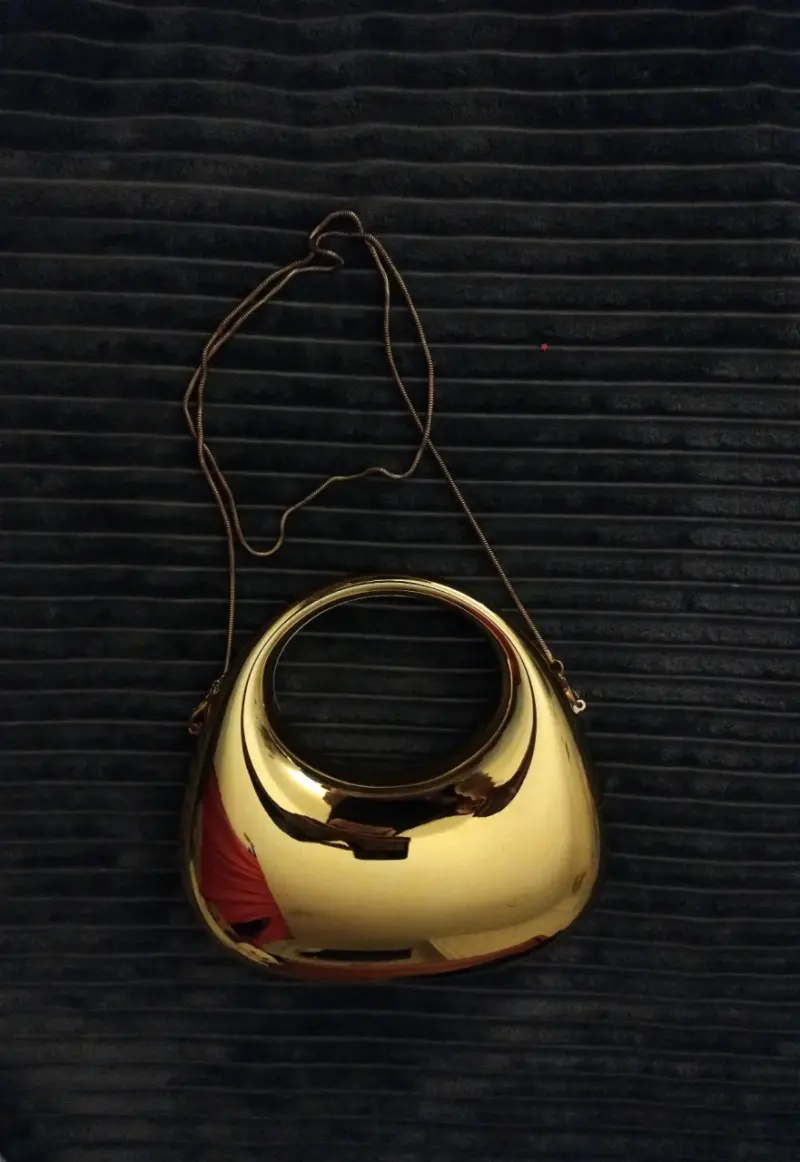 Cartera dorada metálica con correa