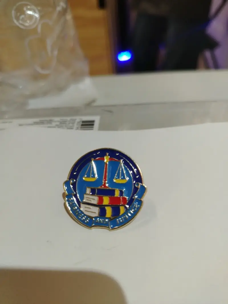 Insignia metálica con diseño de balanza