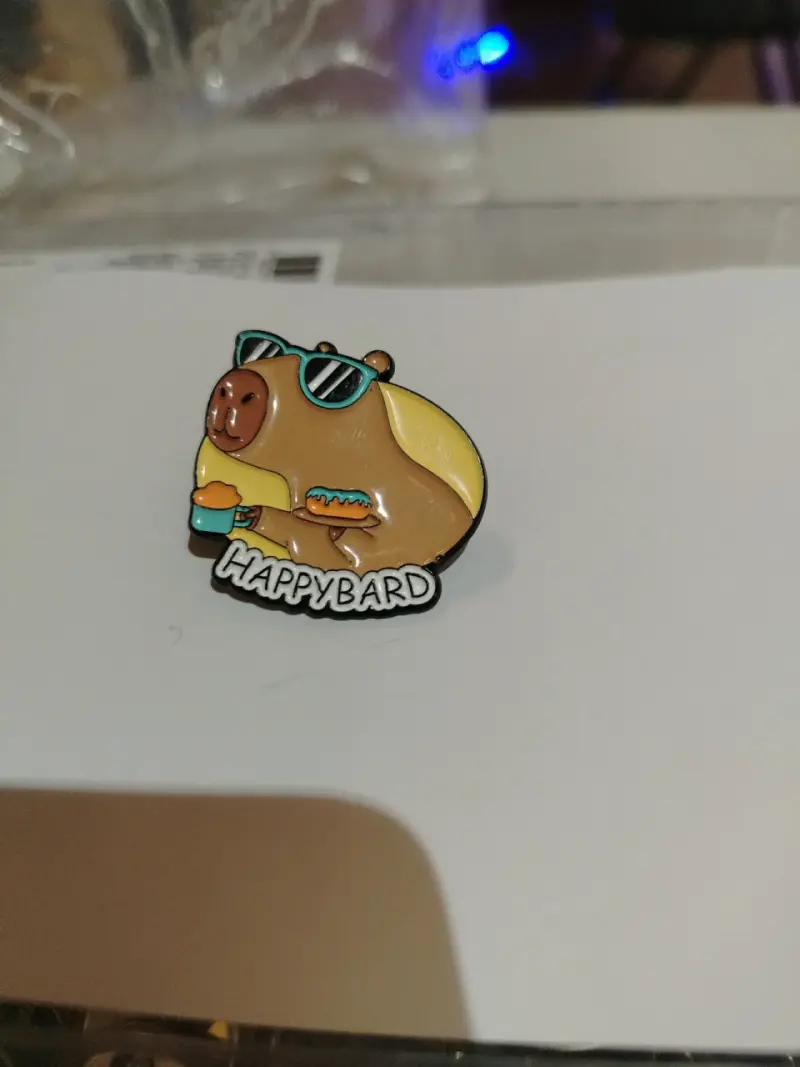 Pin de capibara con gafas y bebida