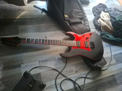 Guitarra eléctrica negra con detalles rojos - miniatura 1