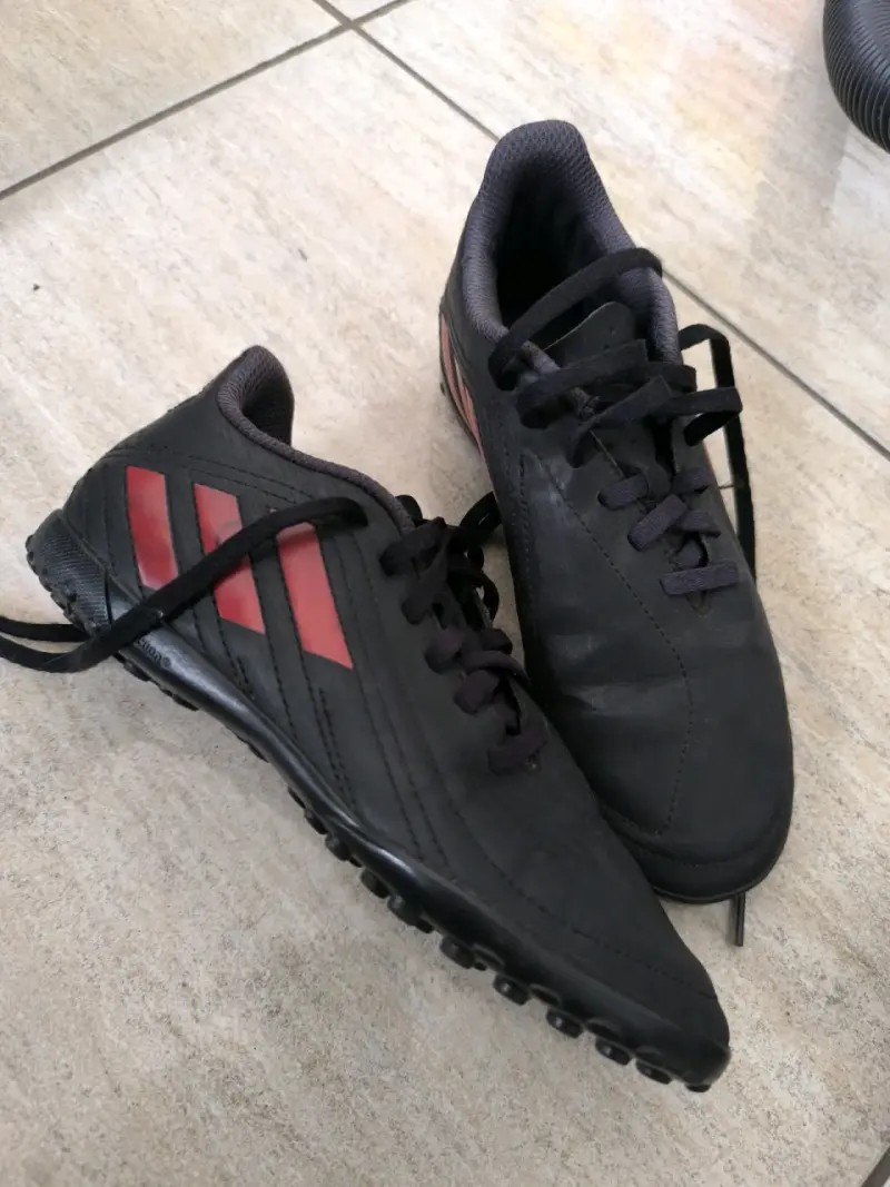 Zapatillas de fútbol negras con rayas rojas