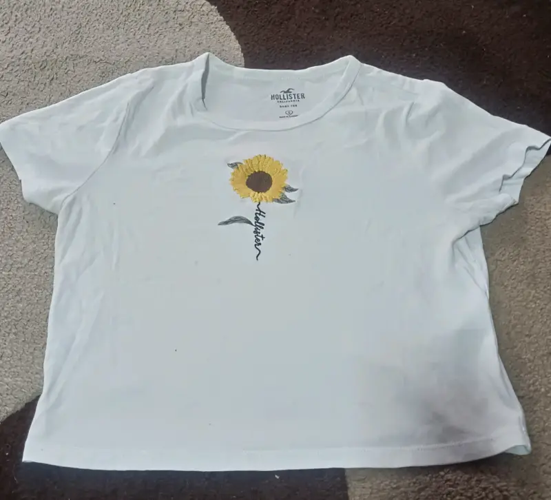 Polera Hollister blanca con girasol bordado