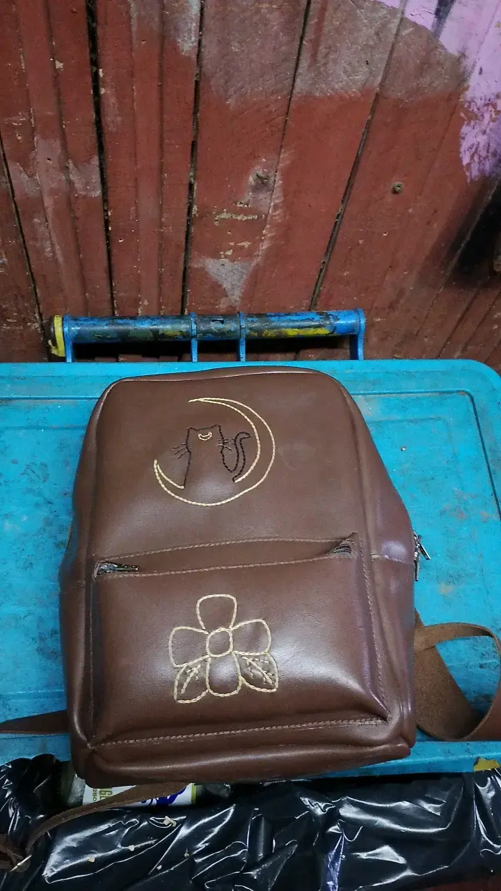 Mochila de cuero marrón con bordado