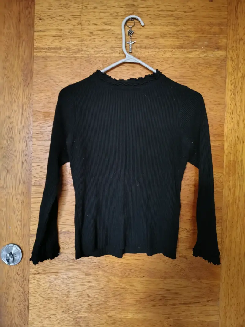 Suéter negro de punto con cuello ondulado