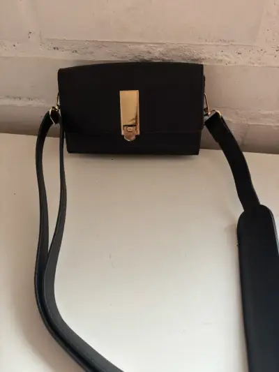 Cartera negra elegante con cierre dorado - miniatura 2