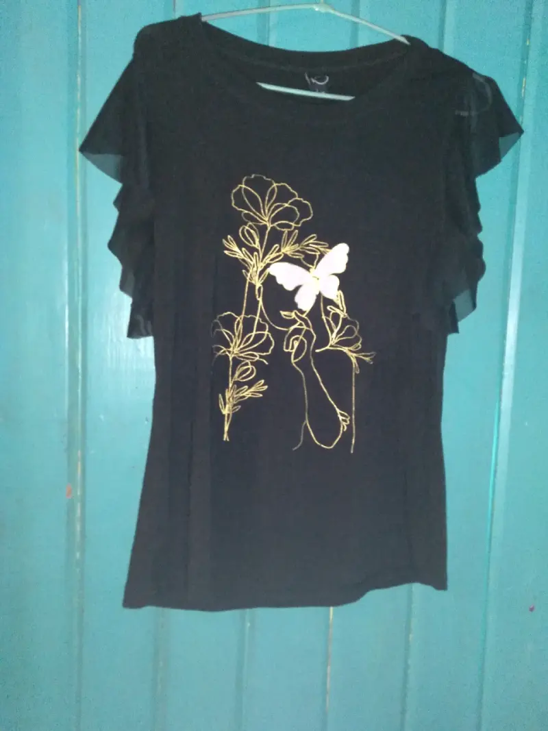 Polera negra con diseño floral y mariposa