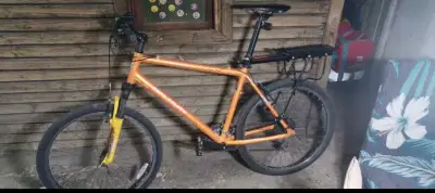 Bicicleta de montaña naranja con portaequipajes - miniatura 1