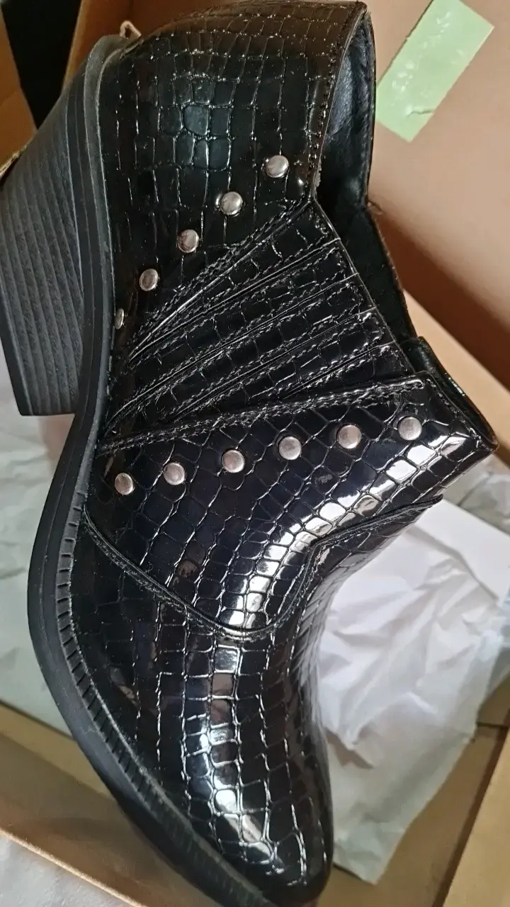 Botines negros de cuero con textura y tachas - 1