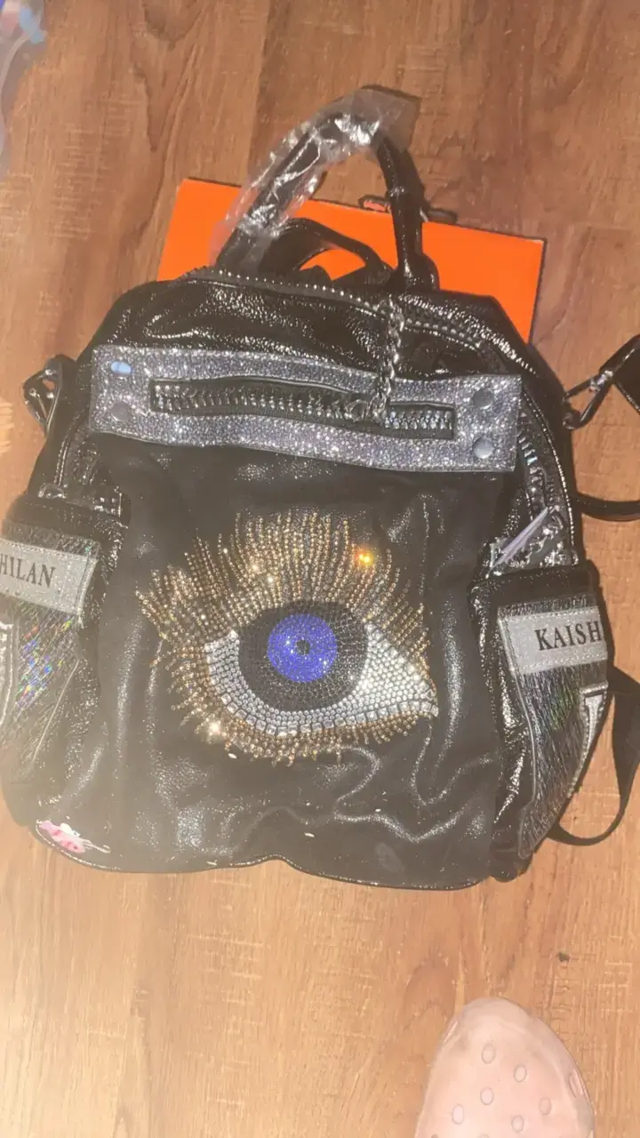 Mochila negra con diseño de ojo brillante
