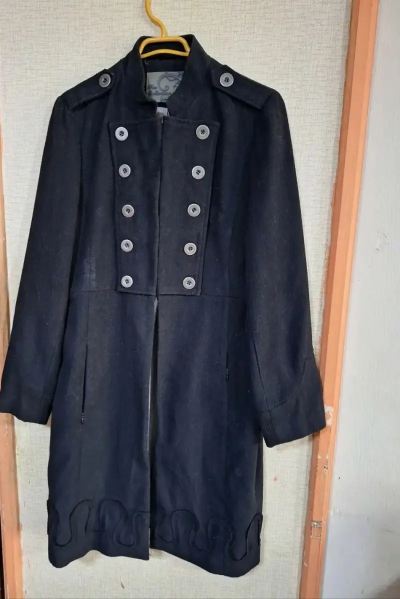 Abrigo negro elegante con botones decorativos