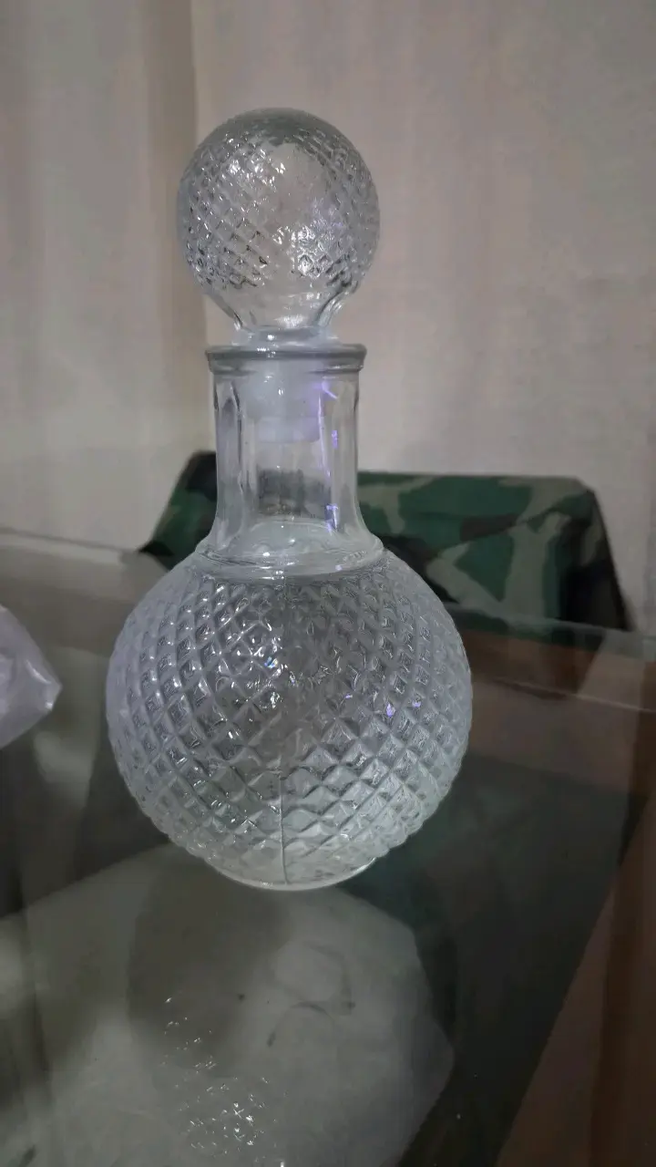 Botella de vidrio con diseño tallado