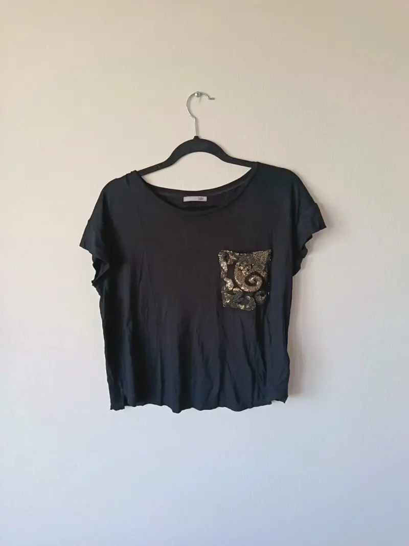 Polera negra con bolsillo decorativo