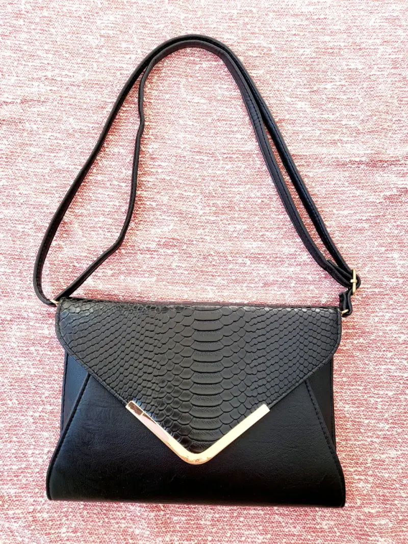 Cartera negra con diseño de reptil