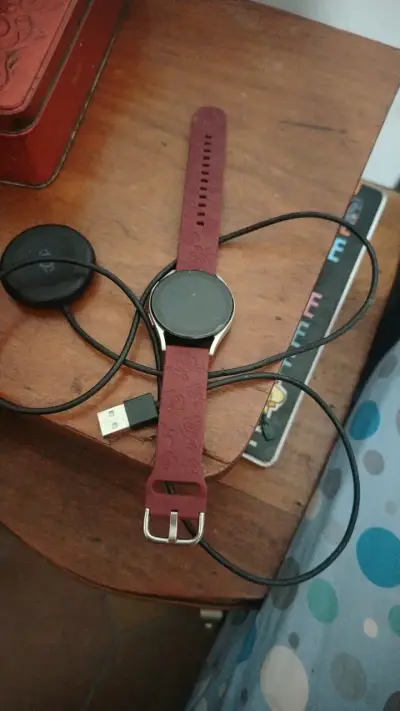 Smartwatch con correa roja y cargador - miniatura 1
