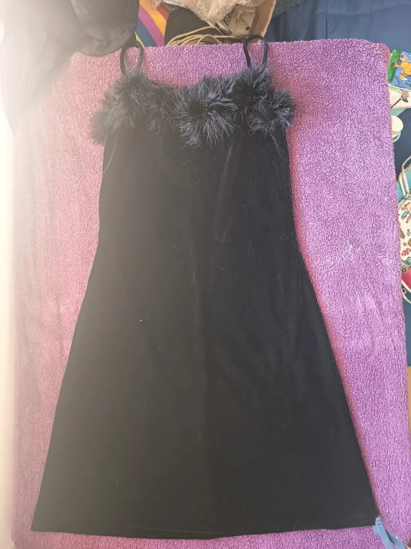 Vestido negro con detalles de plumas