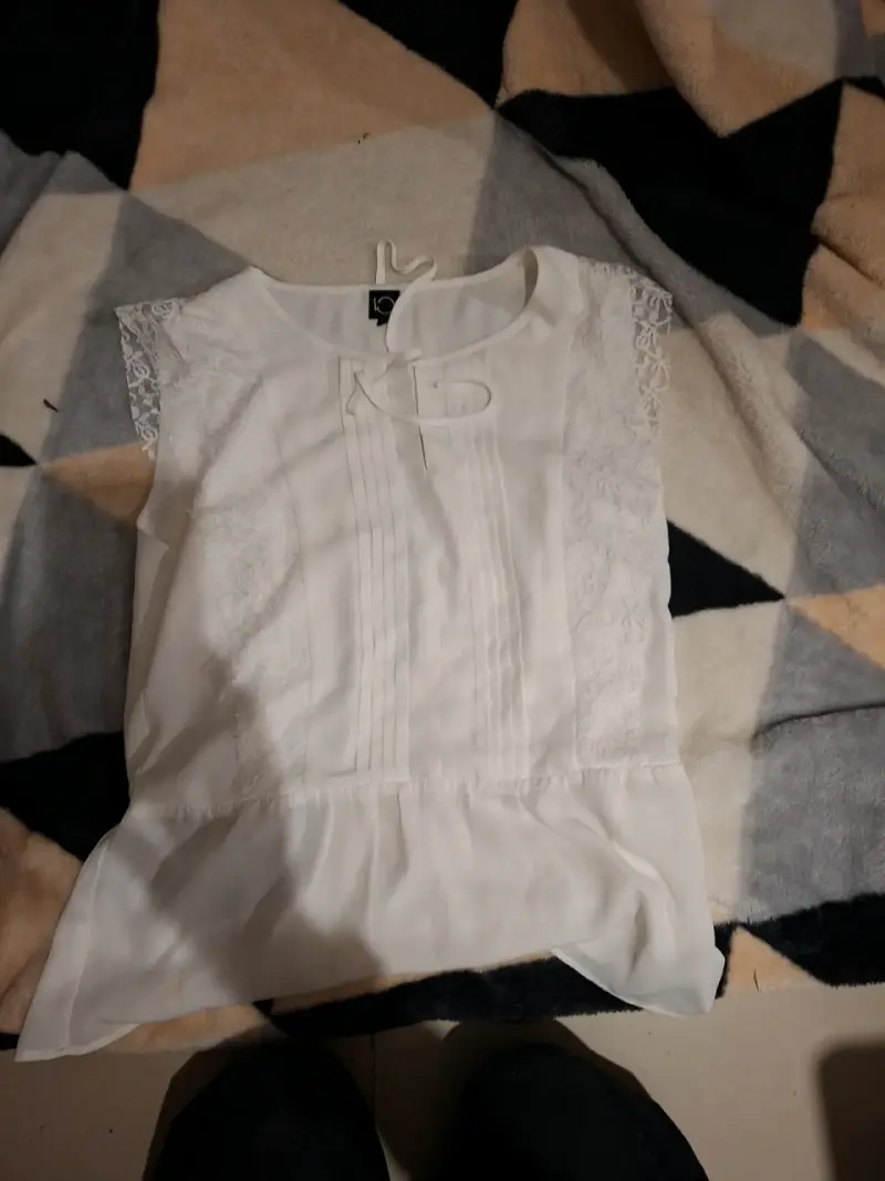 Blusa blanca con encaje y pliegues