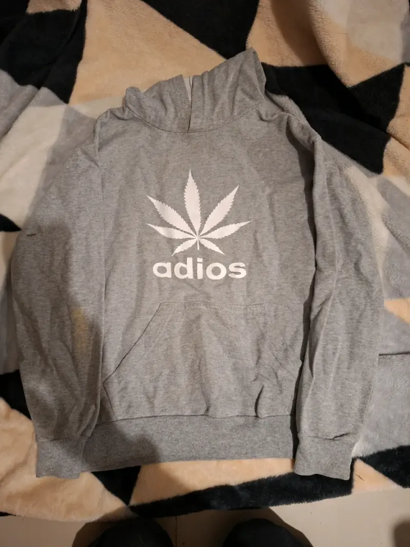 Polerón gris con diseño de hoja y texto