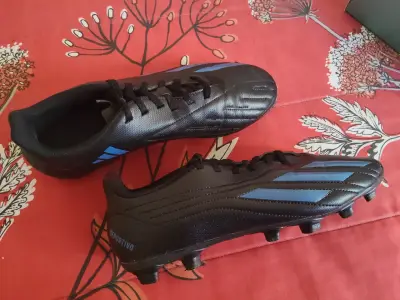 Botines de fútbol negros con detalles azules - miniatura 1