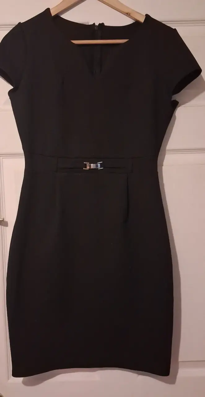 Vestido negro elegante con cinturón metálico